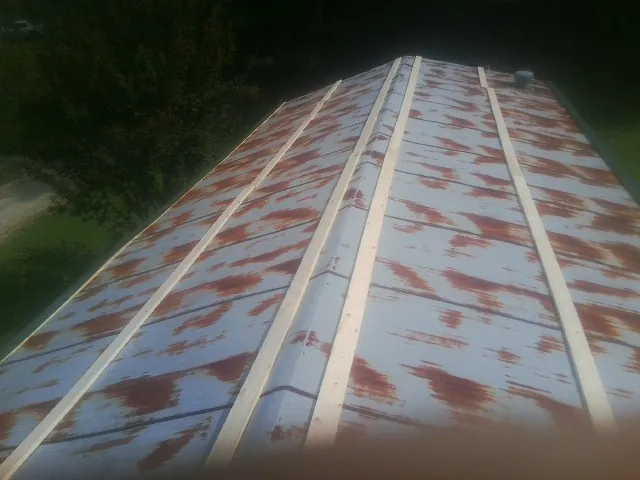 Rusted metal roof panels with new wood purlins before replacement — Storm Damage Roof Repair in East Dennis by Roofing Brothers