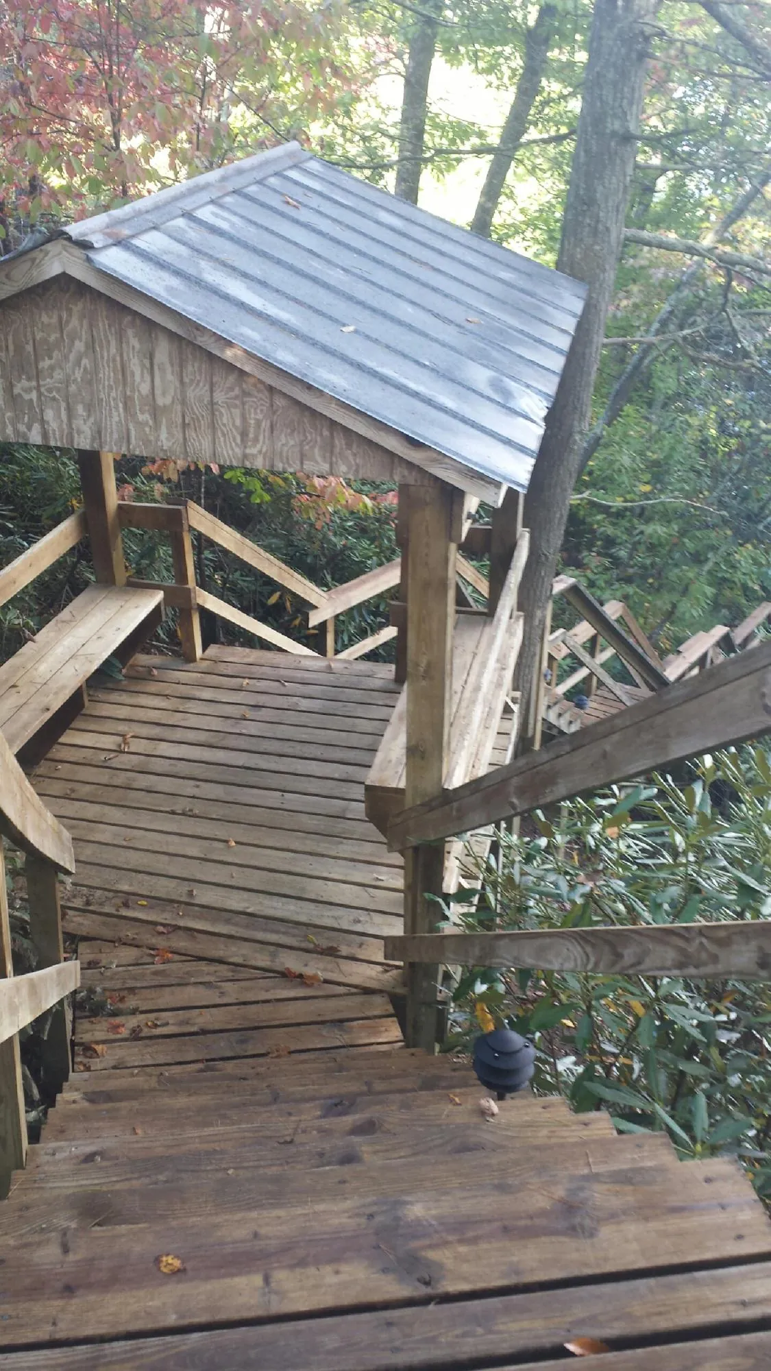 Metal roofed shelter over wooden steps on a wooded walkway — Skylight Repair & Installation work by our crew in East Dennis