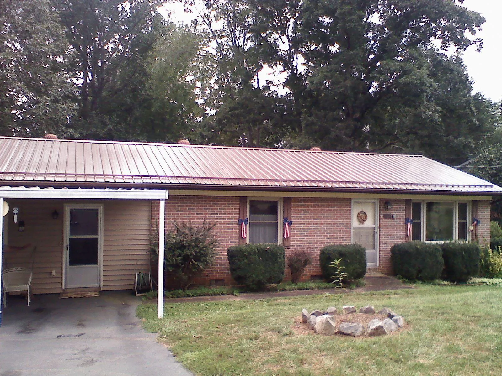 Bronze metal roof and carport on a brick ranch home — Roof Repair work by our crew in East Dennis